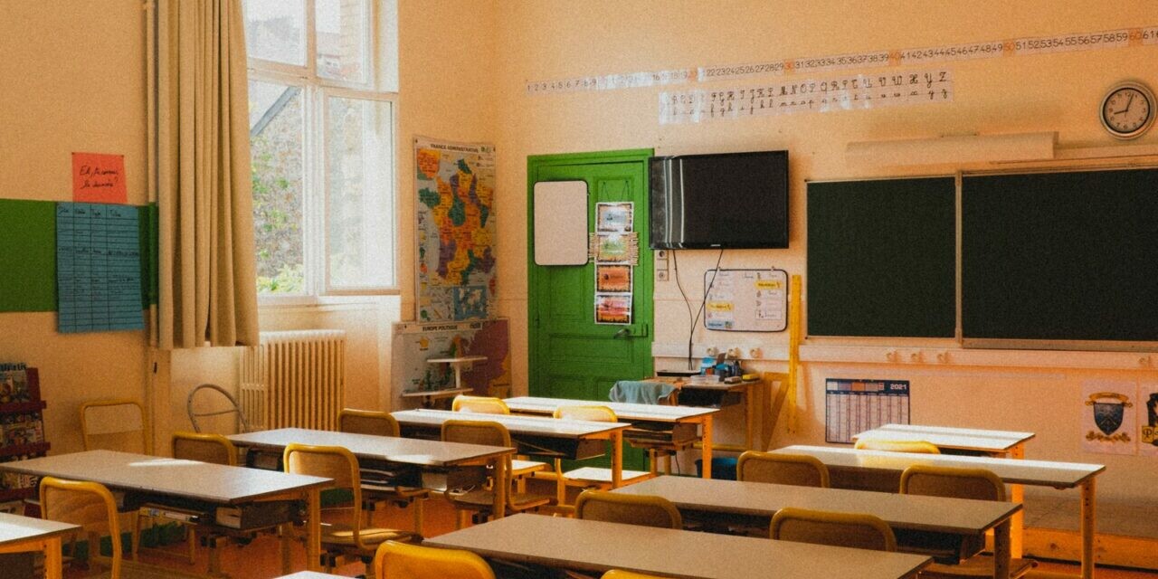Salle de classe lumineuse et vide avec pupitres et chaises