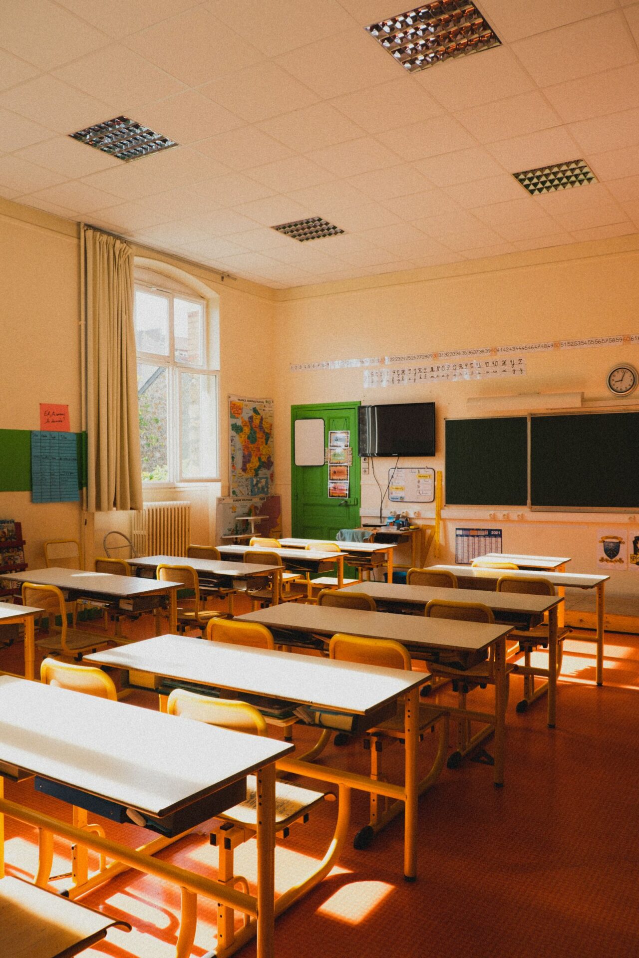 Salle de classe lumineuse et vide avec pupitres et chaises