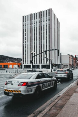 Voiture de police identifiée circulant dans une rue urbaine au Canada