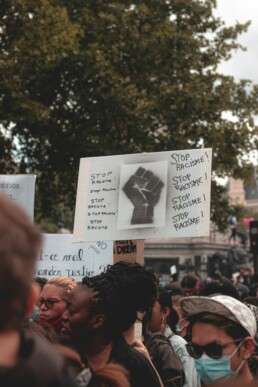 Manifestation pacifique contre le racisme avec pancartes « Stop racisme » et poing levé