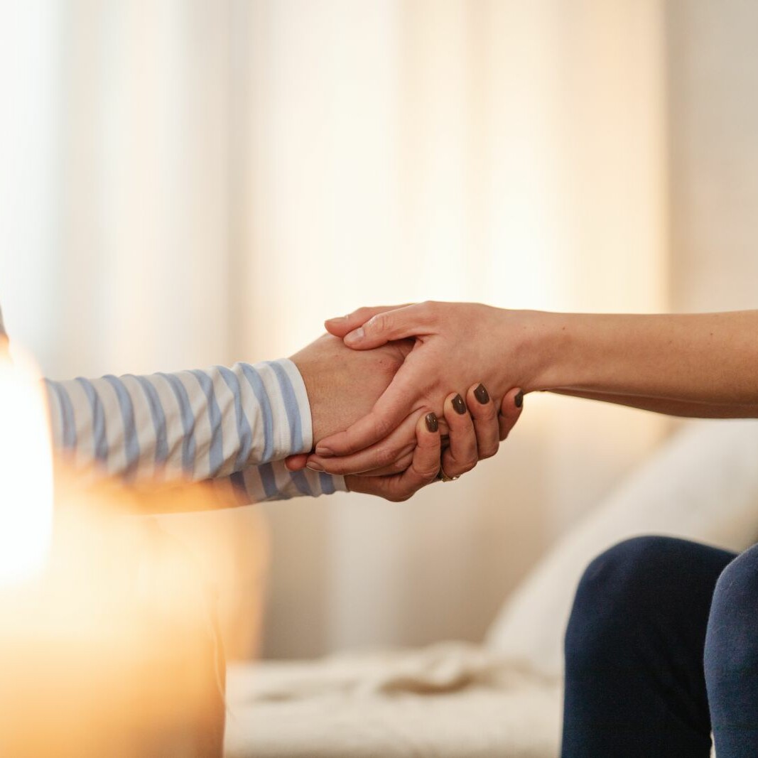 Deux personnes se tenant les mains en signe de soutien et de réconfort