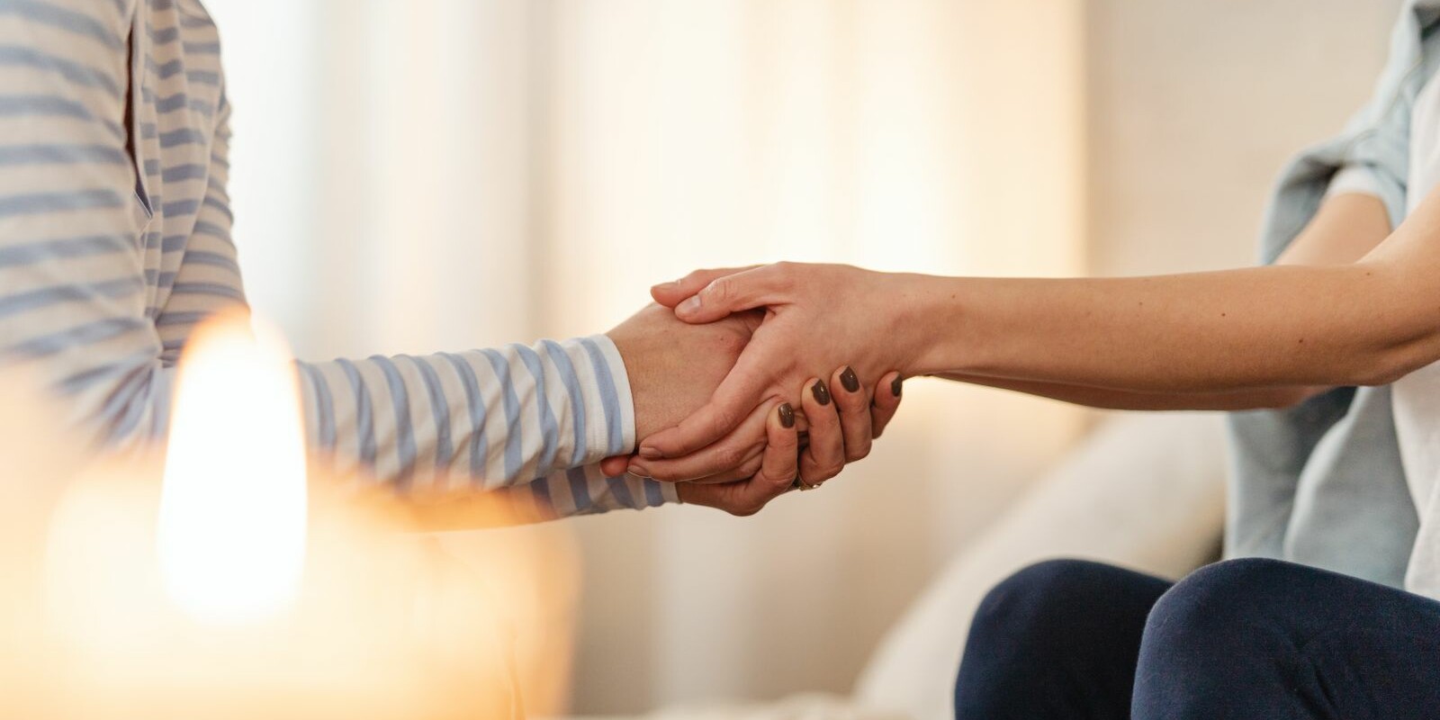 Deux personnes se tenant les mains en signe de soutien et de réconfort