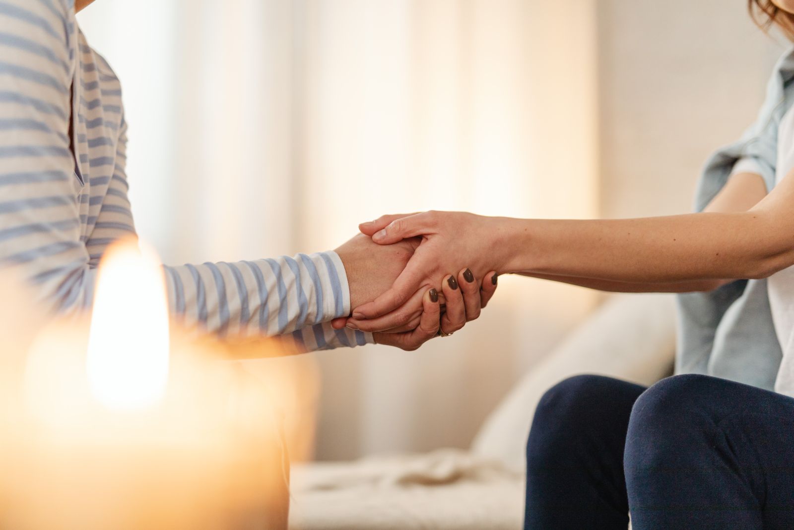 Deux personnes se tenant les mains en signe de soutien et de réconfort